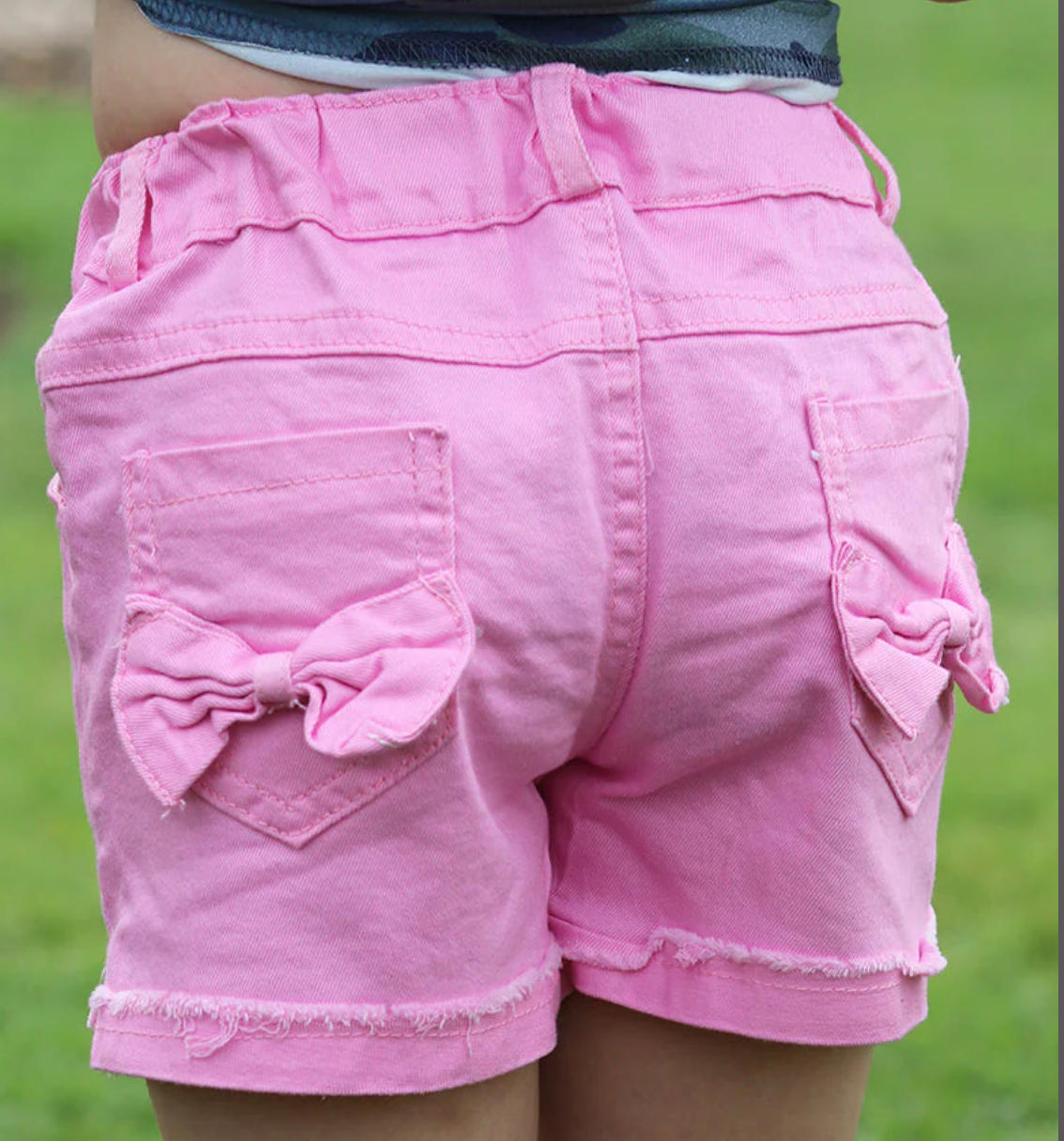 Pink denim shorts with bow detail on back